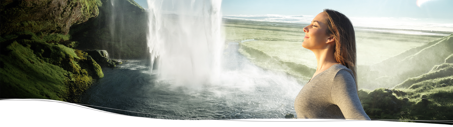 Eine Frau atmet frische Luft am Rande eines Wasserfalls